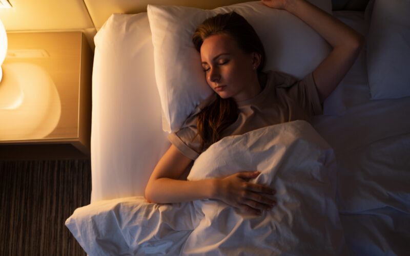 間接照明のやわらかな光の中で眠る女性